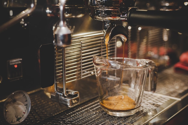 バリスタはカフェでコーヒーマシンを使用しています。
