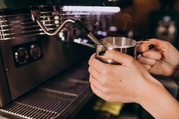 コーヒーマシンでコーヒーを暖めるバリスタ