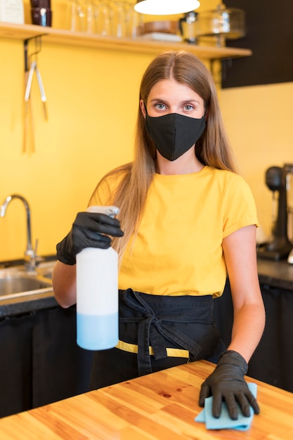 Barista wearing mask and disinfecting
