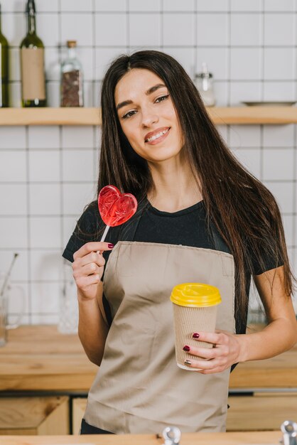 Barista with cup and heart lollipop