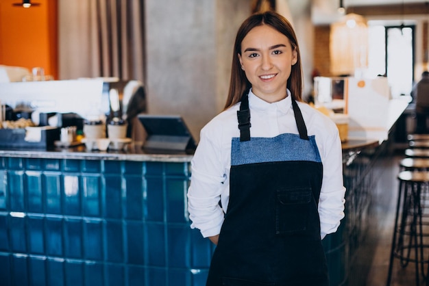 Barista woman at coffee shop standing by the bartender