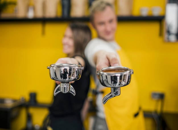 Free photo baristas posing back to back while holding cups