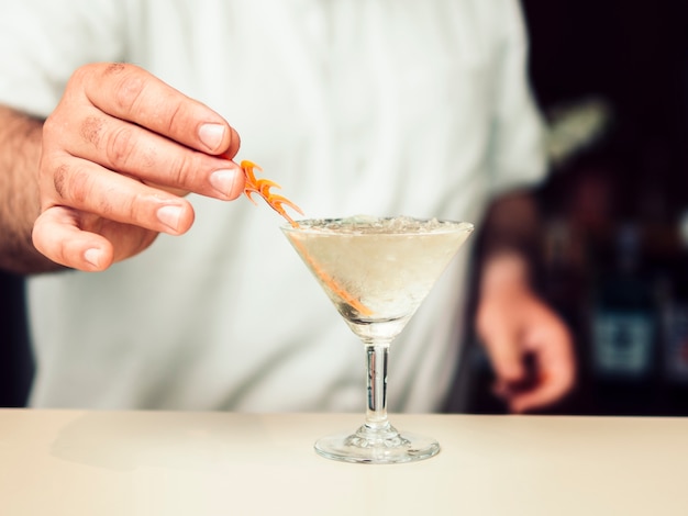 Barman adding decoration to cocktail