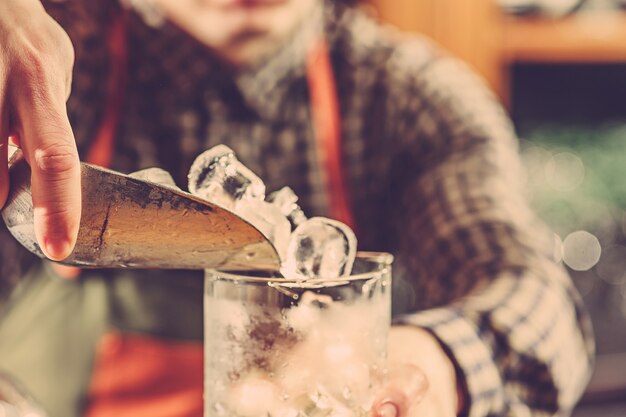 Barman making an alcoholic cocktail at the bar counter on the bar