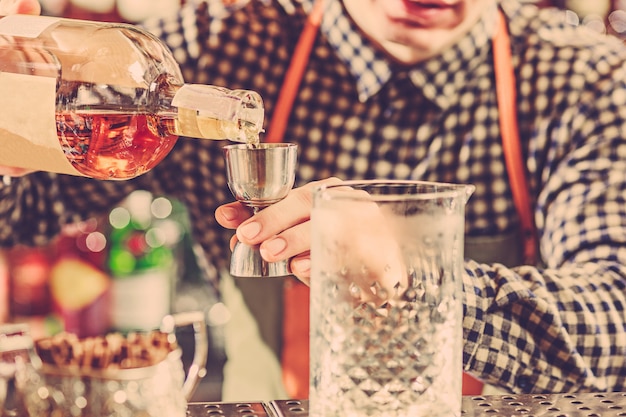 Foto gratuita barista che produce un cocktail alcolico al bancone del bar sulla barra