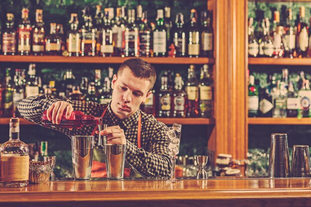 Foto gratuita barman che prepara un cocktail alcolico al bancone del bar