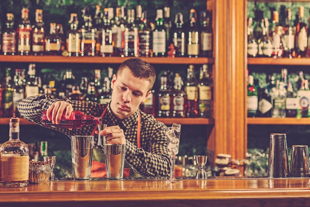 Barman making an alcoholic cocktail at the bar counter