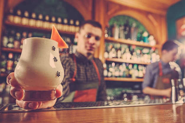 Il barista offre un cocktail alcolico al bancone del bar nello spazio del bar