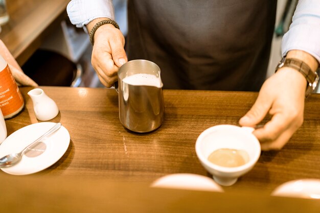 Barman with coffee and milk