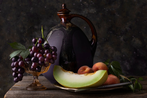 Free photo baroque style with bottle and fruits arrangement