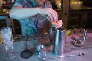 Free photo bartender adding egg yolk while preparing drink at counter