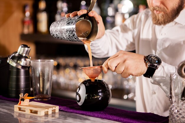 Bartender bartender is pouring a drink. Alcoholic drink