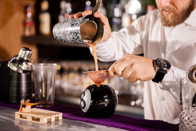 Bartender bartender is pouring a drink. Alcoholic drink