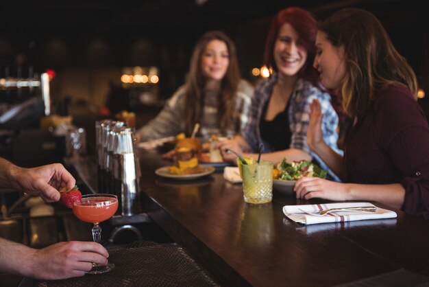 Bartender holding cocktail at bar counter