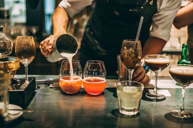 バーテンダーがアルコールカクテル、バーで夏のカクテルを作る