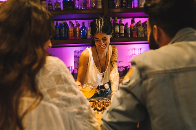 Free photo bartender making cocktail for couple