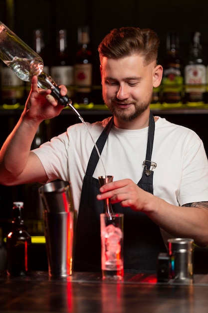 Foto gratuita barista che prepara un cocktail con uno shaker