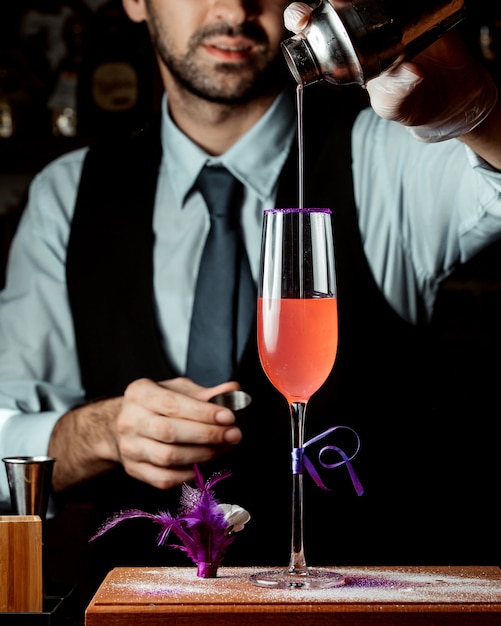 Bartender pours cocktail from cocktail shaker