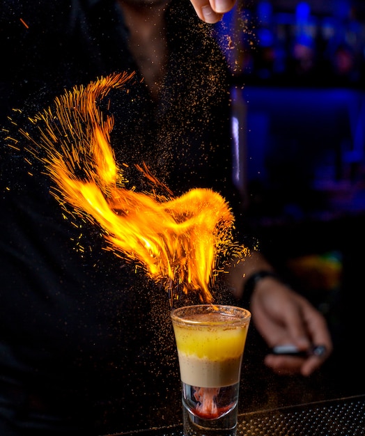 Bartender pours powder into a shot