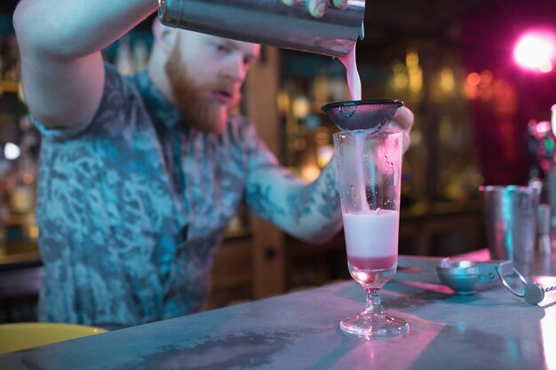 Bartender preparing a cocktail at counter