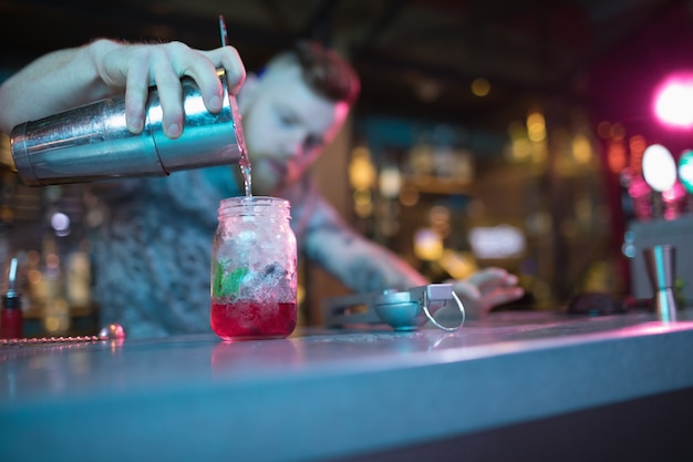 Free photo bartender preparing cocktail at counter