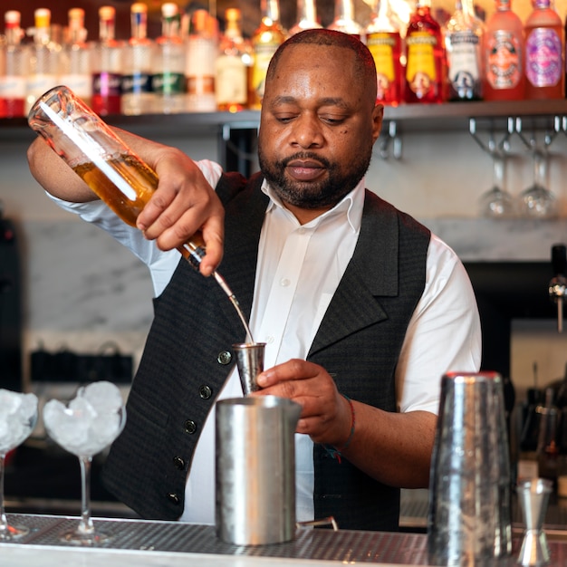 Free photo bartender preparing drink at bar