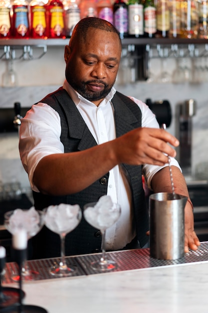 Free photo bartender preparing drink at bar