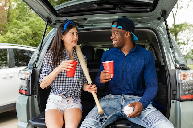 Free photo baseball fans sitting in car boot at a tailgate party