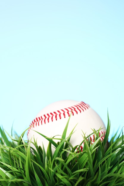 Baseball in grass on blue