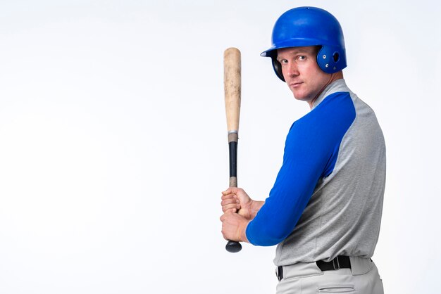 Baseball player posing while holding bat