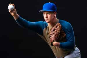 Free photo baseball player posing with glove and ball