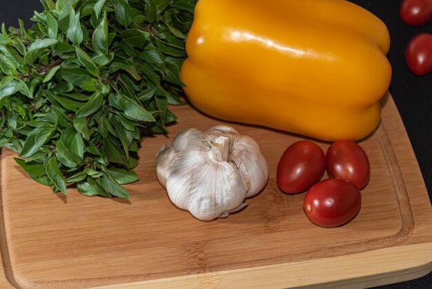 Basil, garlic, peppers and cherry tomatoes on the table Basil, garlic, peppers and cherry tomatoes on the table