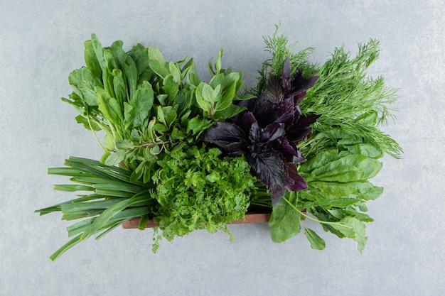 Free photo basil and with parsley in the box, on the marble background.