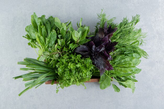 Basil and with parsley in the box, on the marble background.