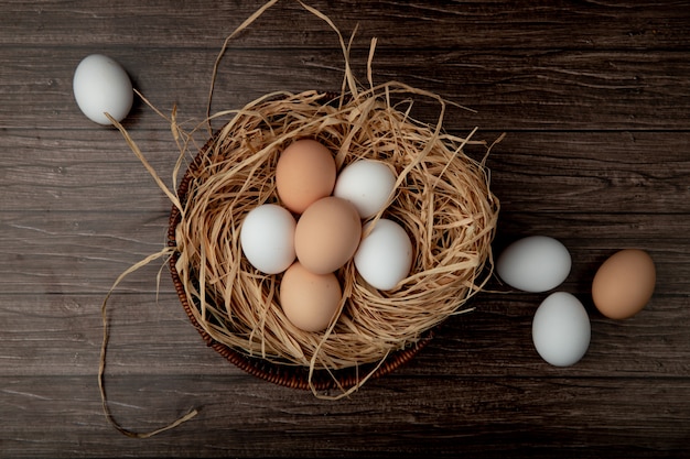  basket of eggs in nest with eggs around on wooden table