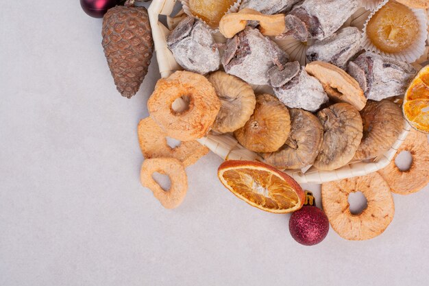 A basket of mixed healthy dried fruits with pinecones . High quality photo