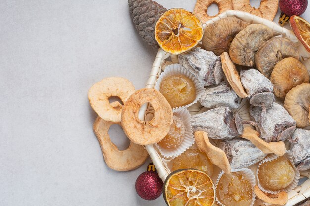 A basket of mixed healthy dried fruits with pinecones . High quality photo