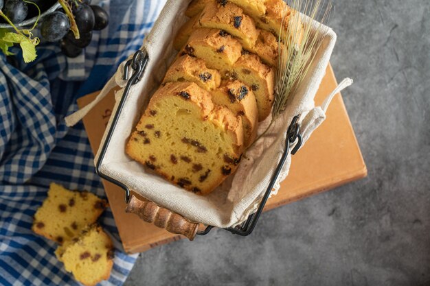 Basket of raisin cake slices on book with tablecloth