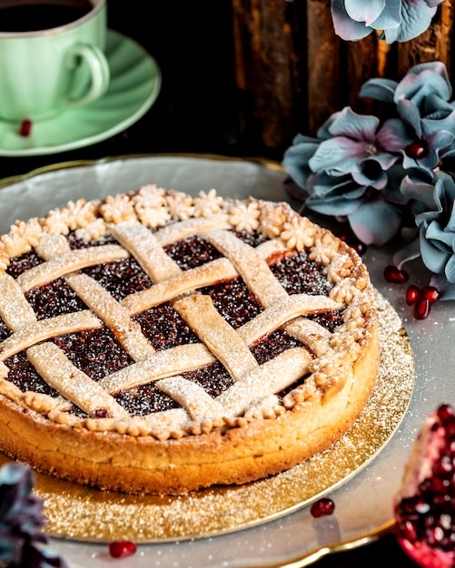 Free photo basket-shaped pomegranate cake sprinkled with powdered sugar