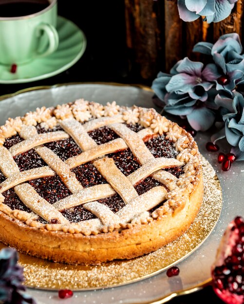 Basket-shaped pomegranate cake sprinkled with powdered sugar