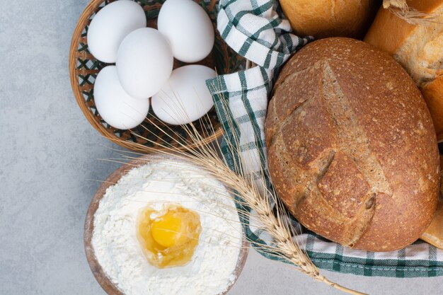 Basket of various bread together with flour and eggs. High quality photo
