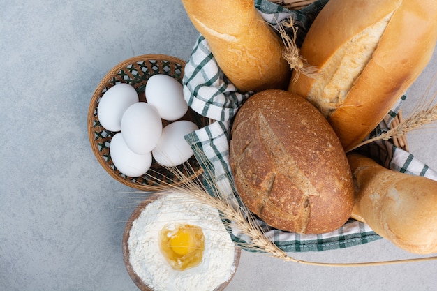 小麦粉と卵と一緒に様々なパンのバスケット。高品質の写真
