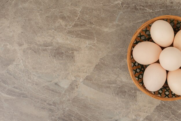 Foto gratuita cesto di uova bianche sul tavolo di marmo.