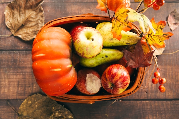Basket with autumnal harvest on table