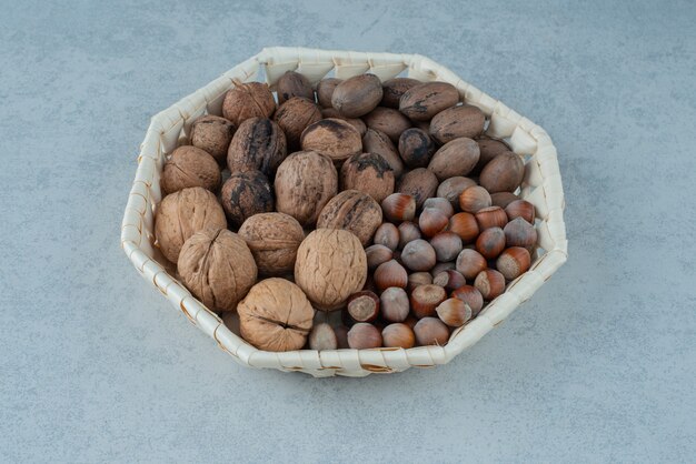 A basket with healthy nuts on marble background. High quality photo