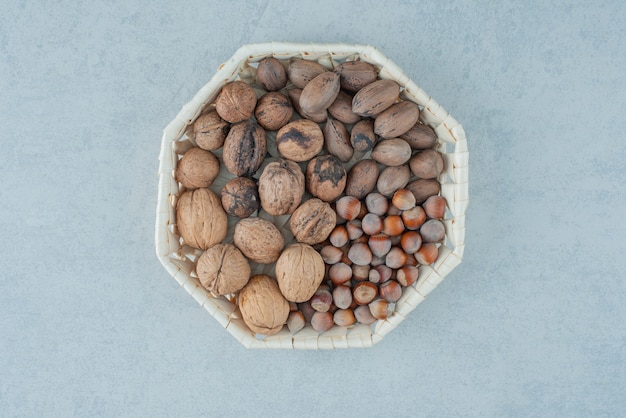 A basket with healthy nuts on marble background. High quality photo