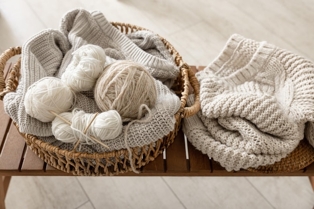 Free photo basket with threads for knitting on a wooden bench in the interior of the room