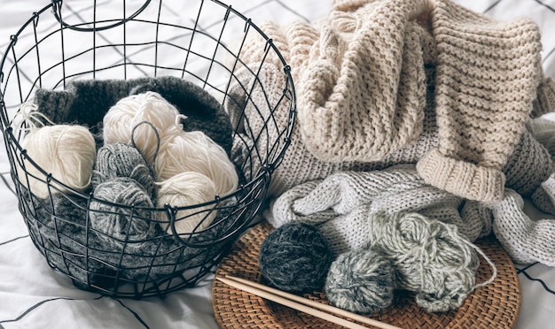 Free photo basket with threads for knitting yarn and knitted items closeup