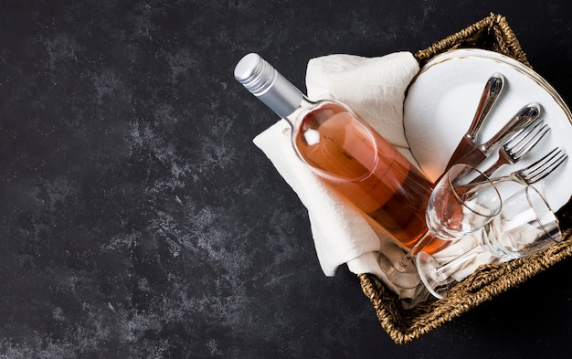 Basket with wine and tableware with copy space