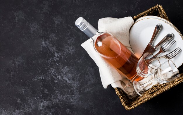 Basket with wine and tableware with copy space